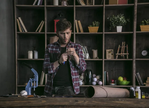 Yakışıklı deri üreticisi ayakta tablo önünde ve iş bitirme