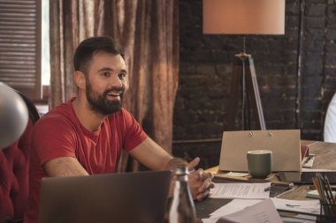 Karanlık office başlangıç oturmuş sakallı genç gülümseyen iş adamı