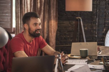 Start rahat karanlık stüdyo ahşap masada oturan genç iş adamı