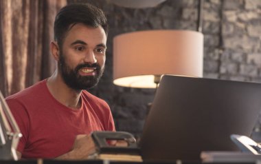 Oturma ve gülümseme ile laptop arıyorum genç işadamı