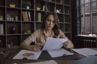 Grafik yatıyordu hangi belgelerle masanın arkasında oturan genç iş kadını