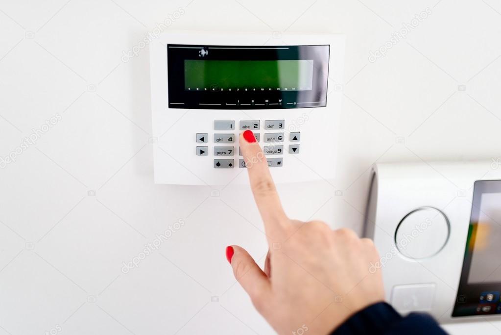Young woman entering security code on keypad
