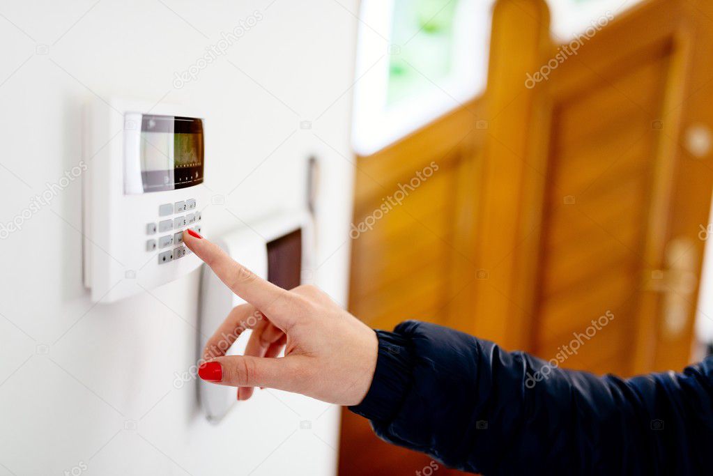 Young woman entering security code on keypad