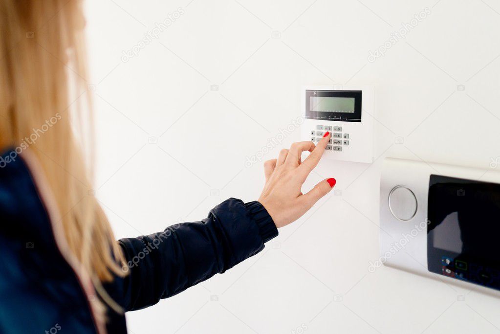 Young woman entering security code on keypad