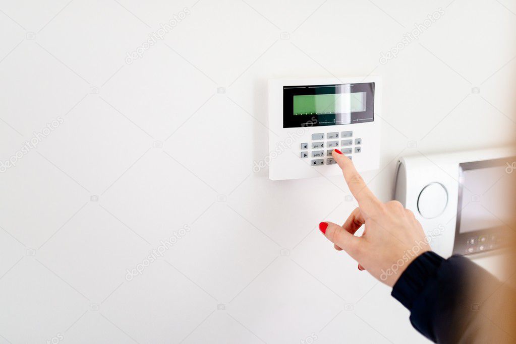 Young woman entering security code on keypad