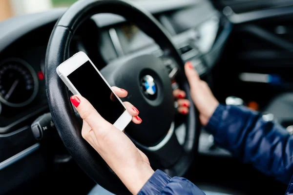 Mujer sosteniendo un teléfono inteligente blanco con pantalla en blanco — Foto de Stock