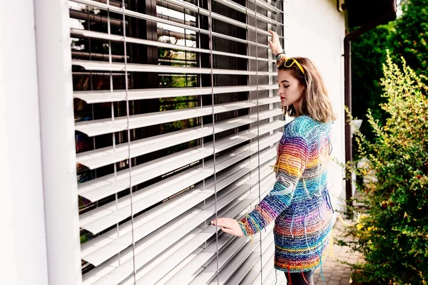 Fajna dziewczyna w kolorowy wełniany sweter pozowanie w ogrodzie — Zdjęcie stockowe