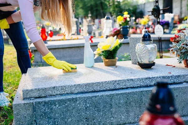 Woman cleans a grave with sponge. — Stockfoto