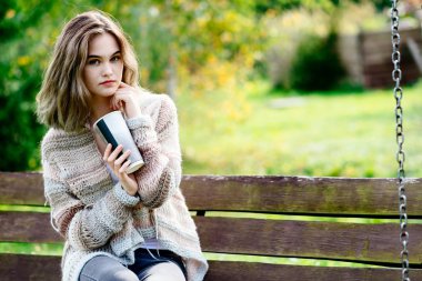 Genç düşünceli kadın bankta rahatlatıcı