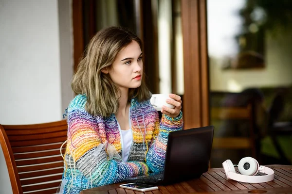 Jovem mulher usa um computador portátil em casa terraço . — Fotografia de Stock