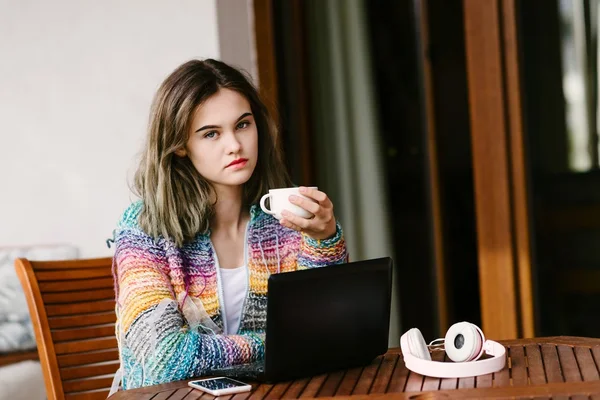 Junge Frau benutzt Laptop auf der heimischen Terrasse. — Stockfoto