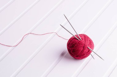 Örgü iğneleri ile kırmızı yün topu