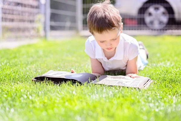 Lilla 7 år gamla pojke beter gamla fotoalbum. — Stockfoto