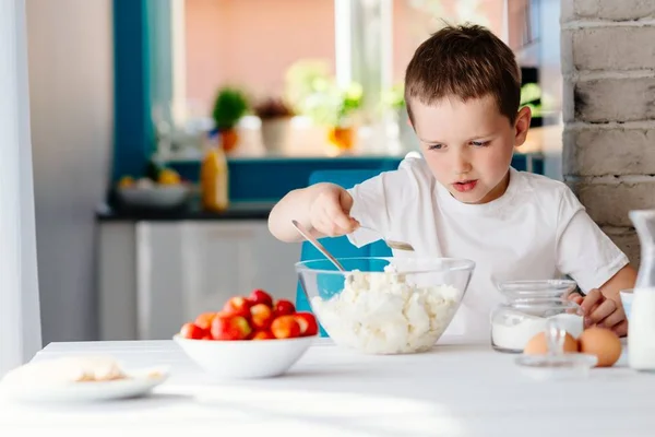 Menino adicionando açúcar ao queijo branco na tigela para cheesecake . — Fotografia de Stock