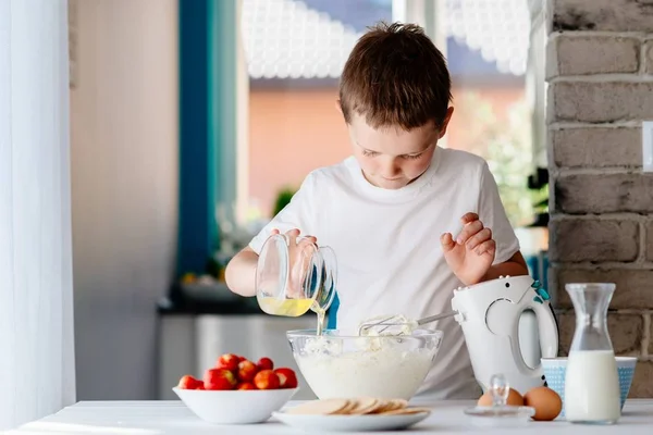 Criança preparando bolo e adicionando ovo branco à massa . — Fotografia de Stock