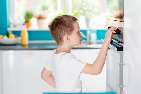 Criança regulando a temperatura do forno  . — Fotografia de Stock
