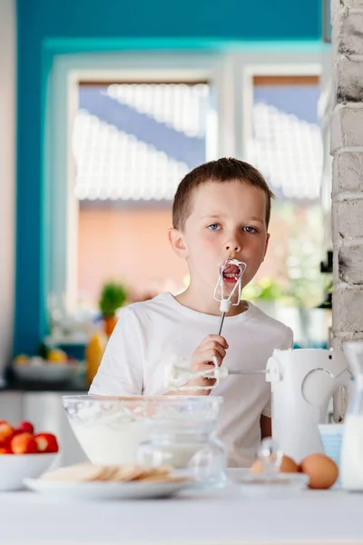 Child tasting pastry from mixer agitator — Stock Photo, Image