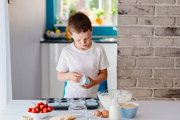 Kind legt Cupcake-Formen in Backblech — Stockfoto