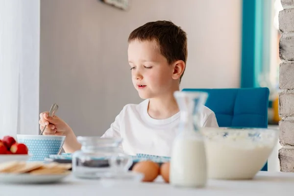 Barn fyller muffins form med degen ingredienser — Stockfoto