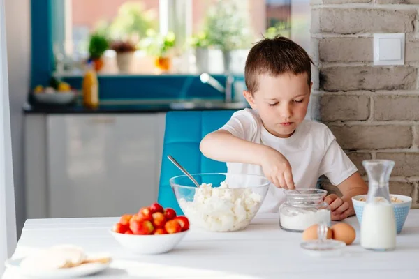 Il ragazzo mescolando il formaggio bianco in boccia per torta di formaggio — Foto Stock