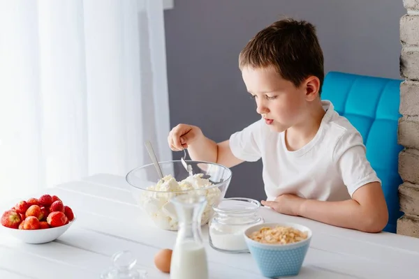 Мальчик добавляет сахар в миску с белым сыром для чизкейка . — стоковое фото