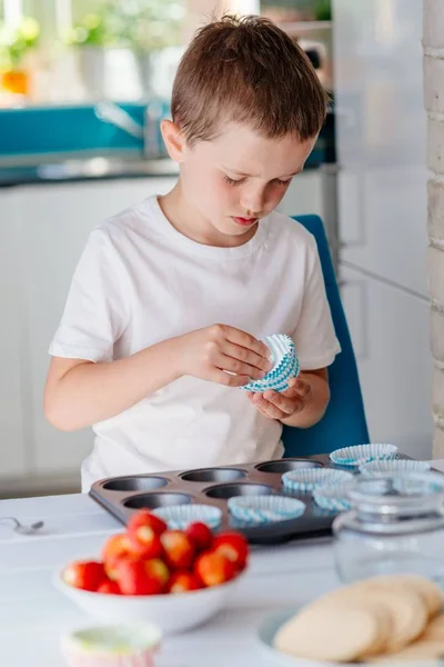 Barn att placera cupcake former i bakning fack — Stockfoto