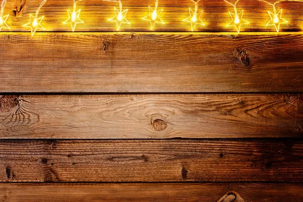 Julbelysning på trä rustik bakgrund. — Stockfoto
