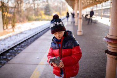 Bir tren bekleyen küçük çocuk çocuk