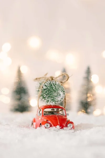 Little red car toy carrying Christmas tree — Stock Photo, Image