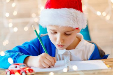 Çocuk evde Noel Baba'ya bir mektup yazma.