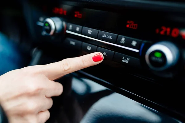 Femme allume la climatisation dans la voiture — Photo