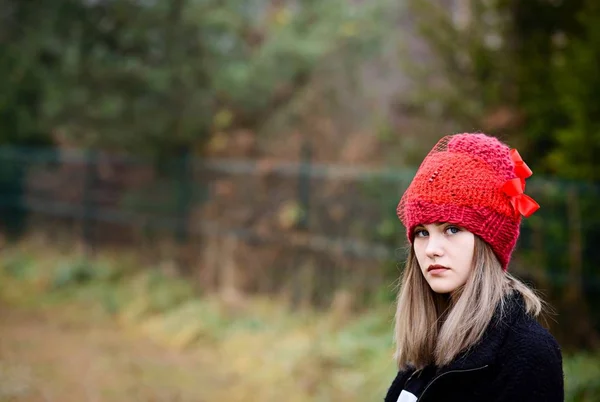 Mujer joven reflexiva en gorra roja de lana — Foto de Stock