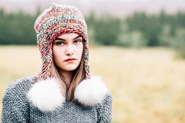 Thoughtful young woman in colorful woolen cap — Stock Photo, Image