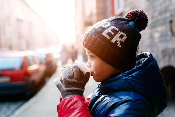 Garçon enfant boire du cacao chaud de tasse en papier — Photo