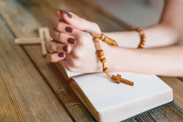 Mani di donne con rosario in legno e Sacra Bibbia — Foto Stock