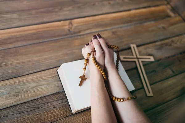 Kadının elleriyle ahşap tespih ve Holy Bible — Stok fotoğraf