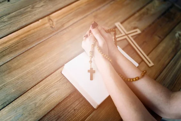 Womans ręce drewniany różaniec i Pismo Święte — Zdjęcie stockowe