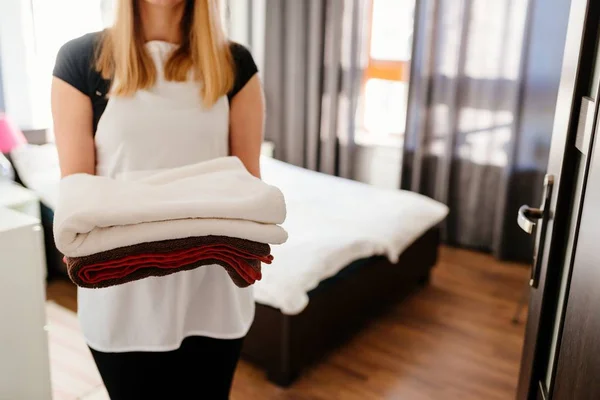 Empregada trazendo toalhas limpas frescas para o quarto — Fotografia de Stock