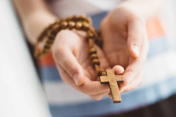 Bambino bambino che prega e tiene il rosario in legno . — Foto Stock