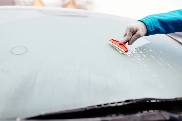 Woman deicing front car windshield with scraper — Stock Photo, Image