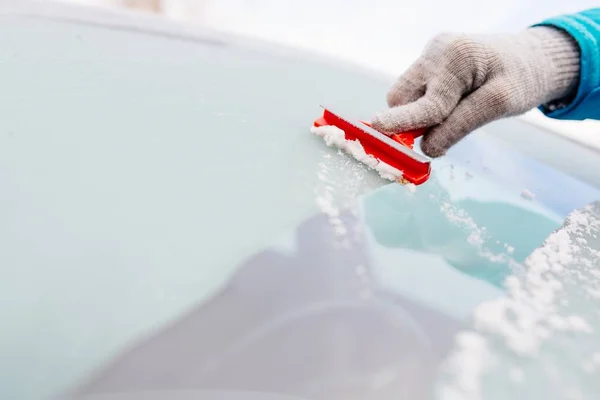 Woman deicing front car windshield with scraper — Stock Photo, Image