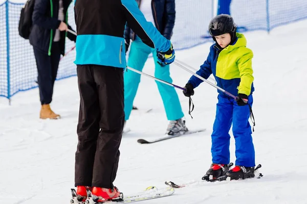 Enfant dans un casque noir apprend à skier avec instructeur — Photo