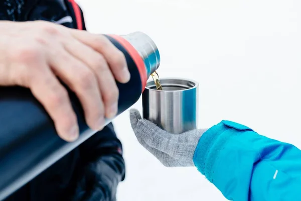 Человек наливает горячий чай из термоса — стоковое фото