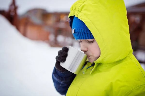 Bambino che beve tè caldo dalla tazza di metallo . — Foto Stock