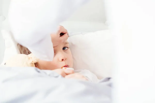 Nemocné malé dítě s teplotou v posteli. — Stock fotografie
