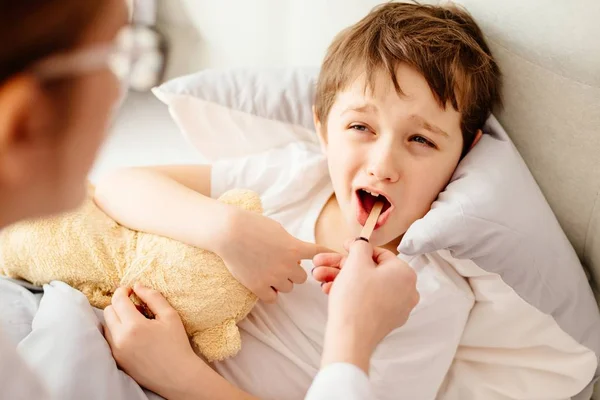 Médico examina enfermo chico garganta — Foto de Stock