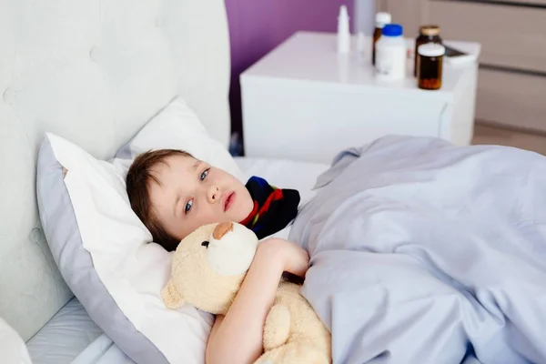 Niña enferma abrazando a un osito de peluche — Foto de Stock