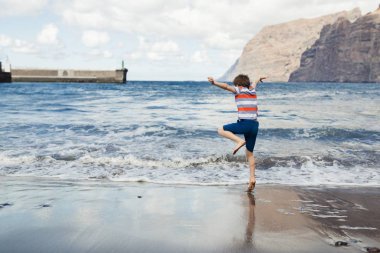 Kumsalda oynayan mutlu çocuk.