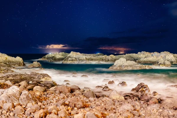 Hermosa vista nocturna sobre el océano y las rocas . — Foto de Stock