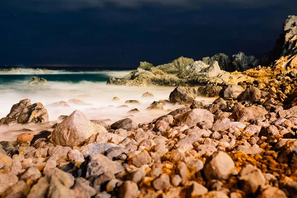 Hermosa vista nocturna sobre el océano y las rocas . — Foto de Stock